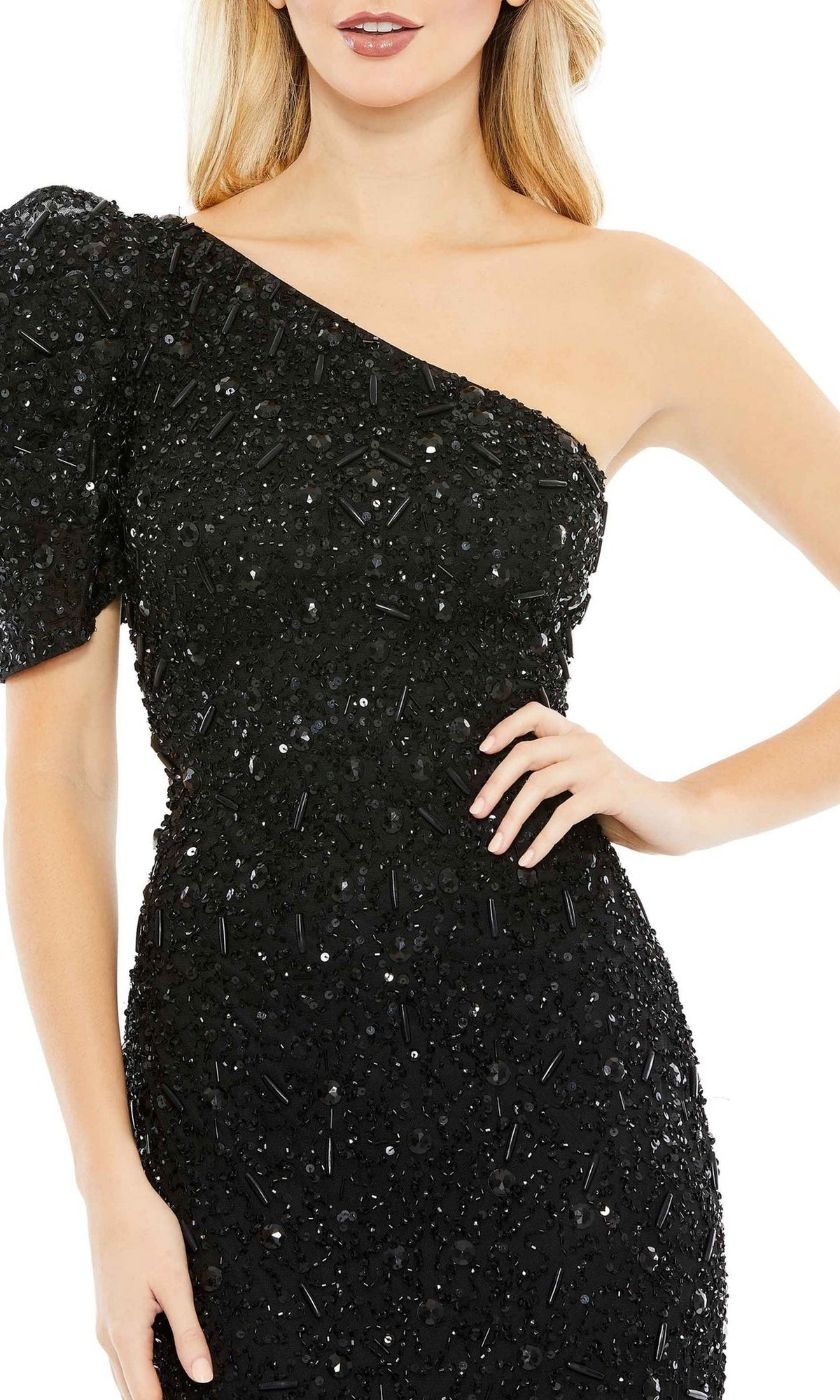 A woman poses confidently with one hand on her hip in the Long Formal Dress 10912 by Mac Duggal—a black, fitted, beaded, one-shoulder gown featuring a short sleeve.